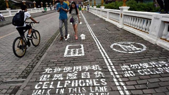 Crean carril exclusivo para peatones que miran el celular en China