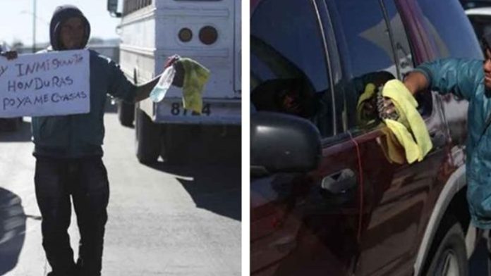 Migrante se gana el día limpiando parabrisas en crucero de Ciudad Juárez