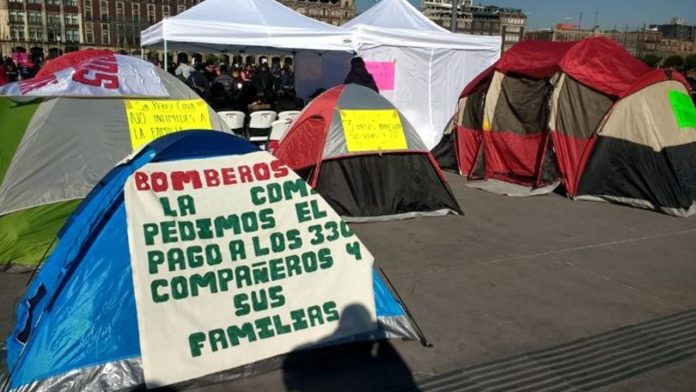 Alrededor de 250 bomberos hacen plantón en el Zócalo de México