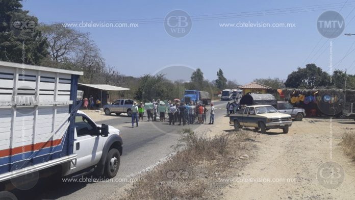 Varias personas, mayoritariamente mujeres y niños se manifiestan en carretera de Zihuatanejo
