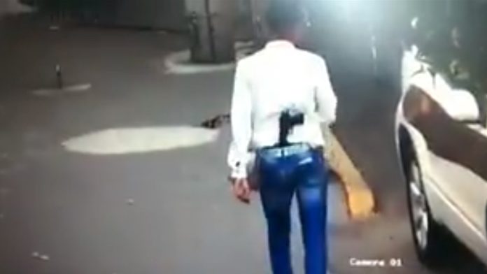 Hombre camina por las calles de México con un arma de fuego