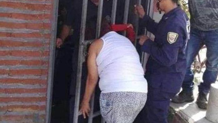 Por andar chismeando en la casa de sus vecinos, mujer se queda atorada en la puerta