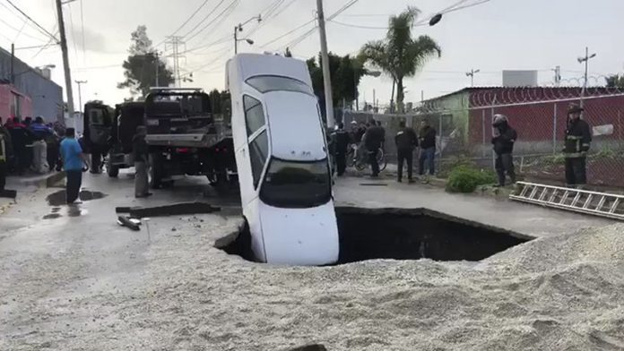 Pasa en México; enorme socavón se traga dos autos (video)