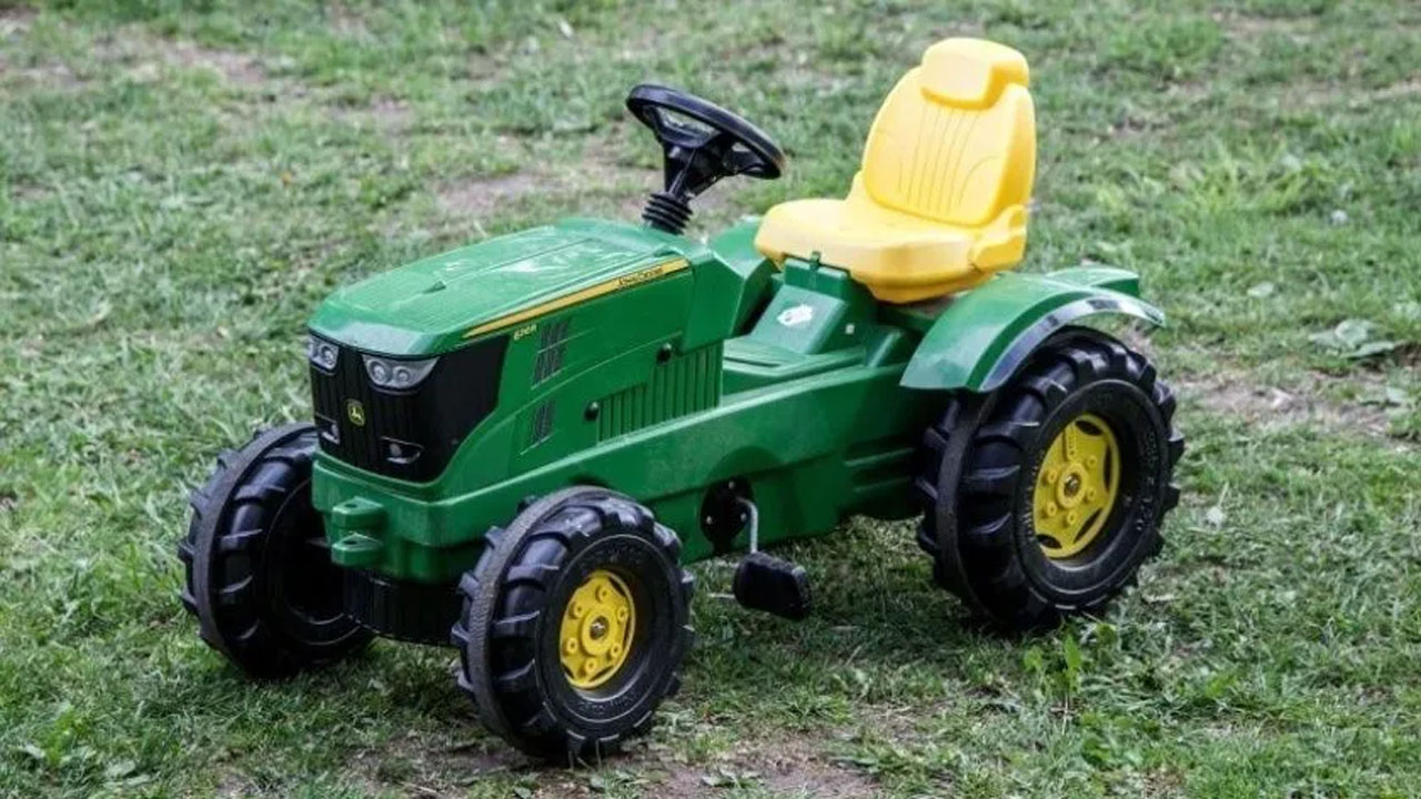 Niño de dos años se escapa a la feria en su tractor de juguete Niño de dos años se escapa a la feria en su tractor de juguete