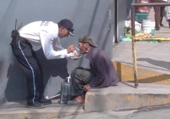 Captan a policía ayudando a un abuelito a alimentarse