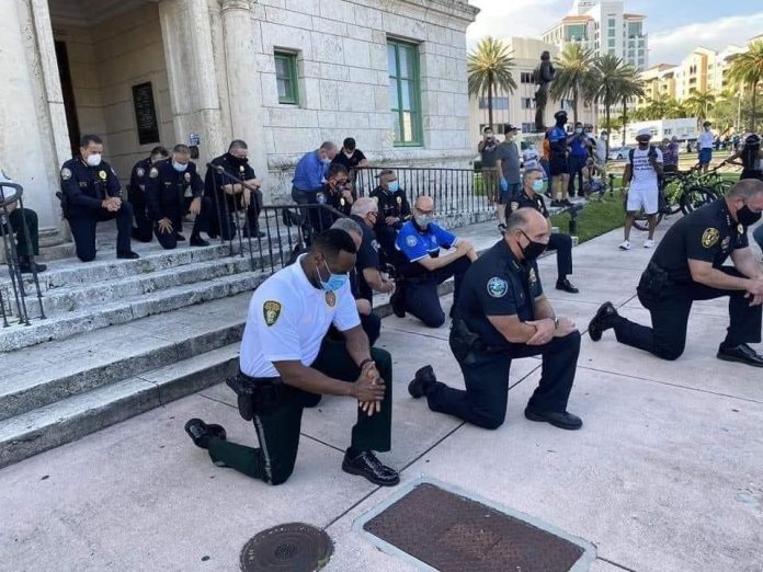 Policías se arrodillan frente a manifestantes en honor a George Floyd