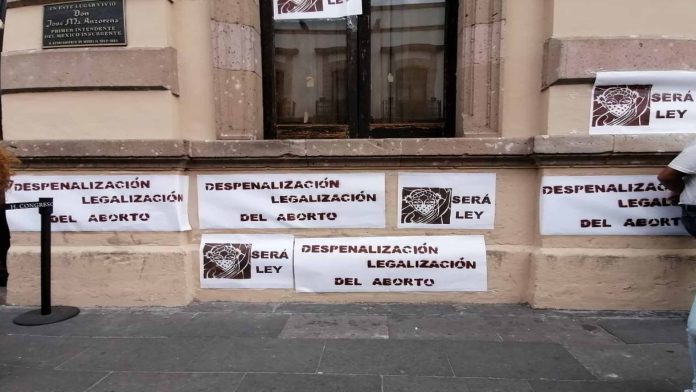 Feministas pegan carteles a favor del aborto afuera del Congreso
