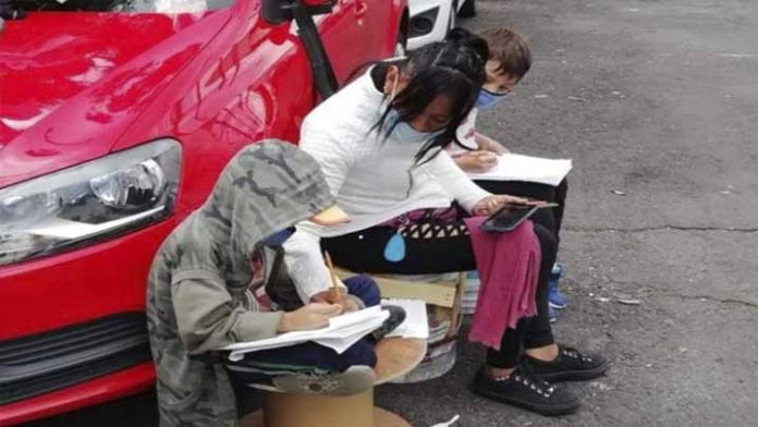 Madre es captada en las calles ayudando a sus hijos a estudiar