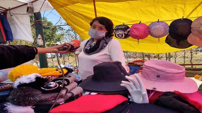 Con poca gente y mínima ganancia comerciantes permanecen en la plaza de la Paz