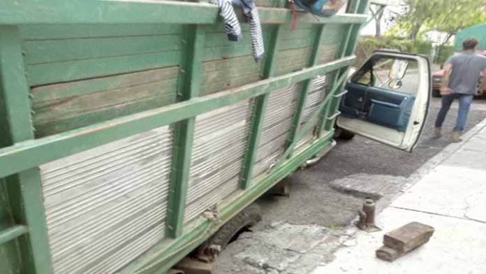 Camión de basura cae en agujero causado por fuga de agua