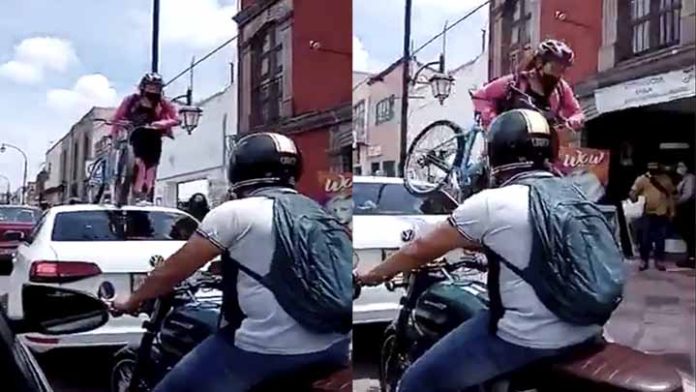 Mujer pasa sobre automóvil que obstruía ciclovía con todo y bicicleta