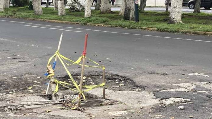 Agregan palos a coladera abierta para evitar que automóviles caigan