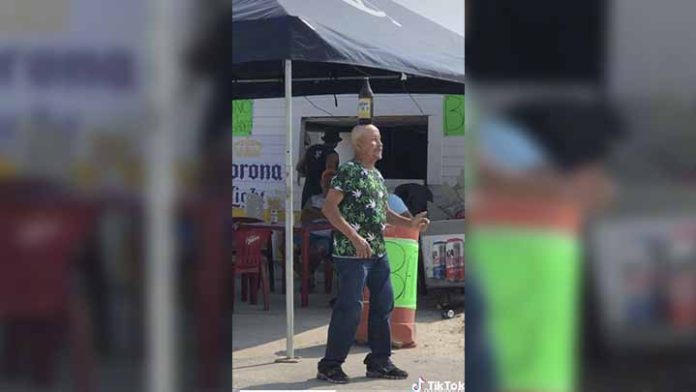 Hombre baila con botella de cerveza en la cabeza