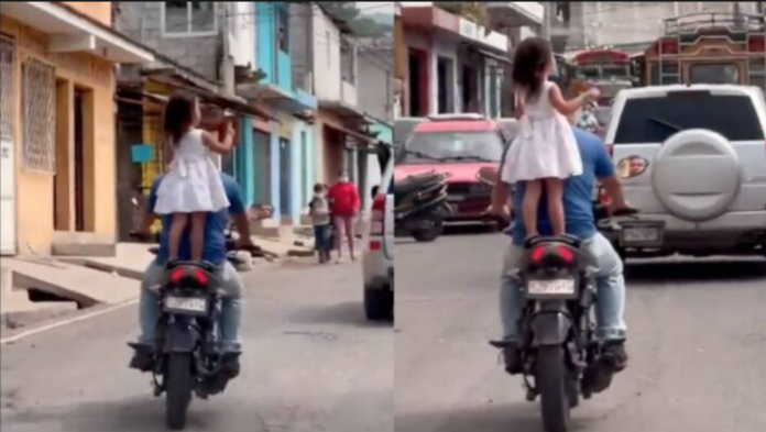 Hombre lleva a su hija parada y sin casco en la moto donde viajan