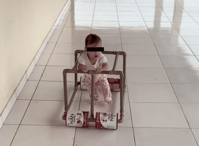 Padre le hace andadera a su bebé con tubos de PVC y latas de leche