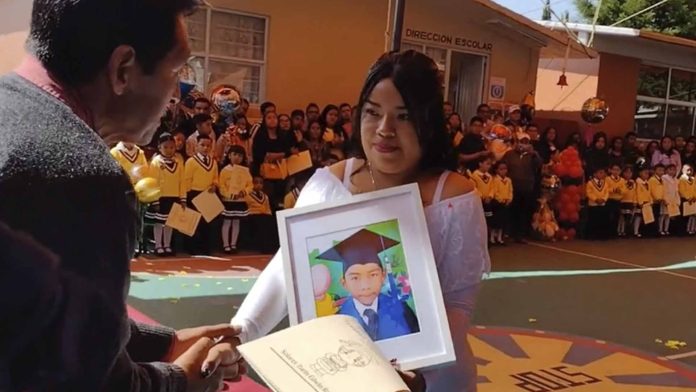 Mujer lleva foto de su hijo fallecido a su graduación