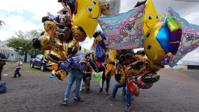 Comerciantes ofrecen precios accesibles de globos y arreglos florales de graduación