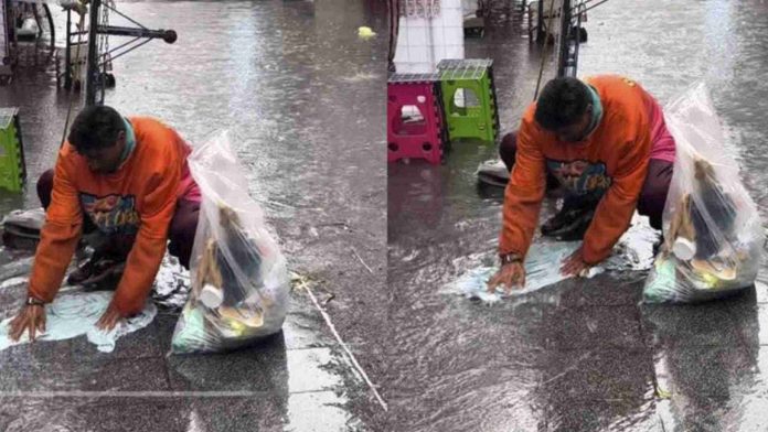 Hombre en situación de calle aprovecha los charcos para lavar su ropa