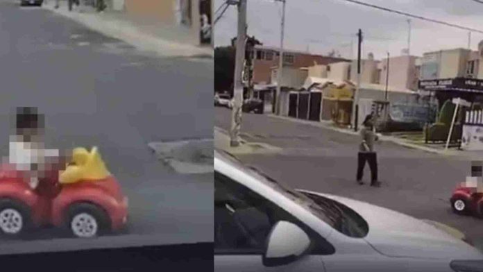 Niño en carrito de juguete cruza en medio del trafico